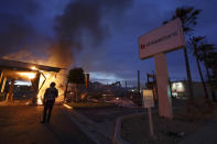 A man looks on as a bank burns after a protest over the death of George Floyd, Sunday, May 31, 2020, in La Mesa, Calif. Protests were held in U.S. cities over the death of Floyd, a black man who died after being restrained by Minneapolis police officers on May 25. (AP Photo/Gregory Bull)