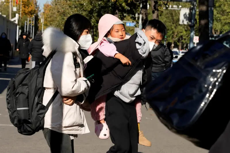 ▲中國多地近日爆發包含黴漿菌在內的呼吸道疾病疫情，兒童感染情況最為嚴重。圖為北京一對父母帶著孩子離開醫院。（圖／美聯社／達志影像）