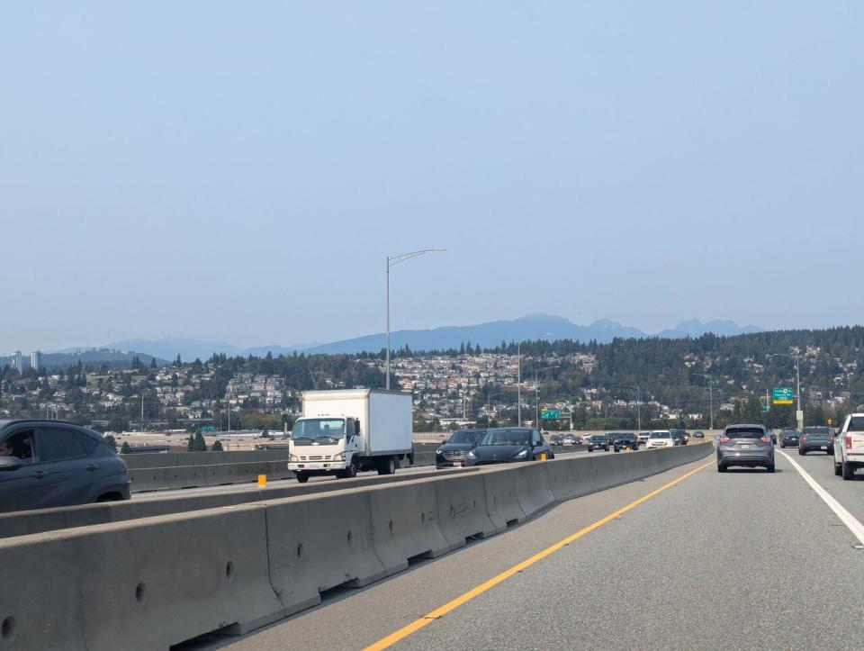 Hazy skies were visible in Metro Vancouver over the weekend due to U.S. wildfires. Here, mountains are seen shrouded by the haze from Surrey's Port Mann Bridge on Sunday.