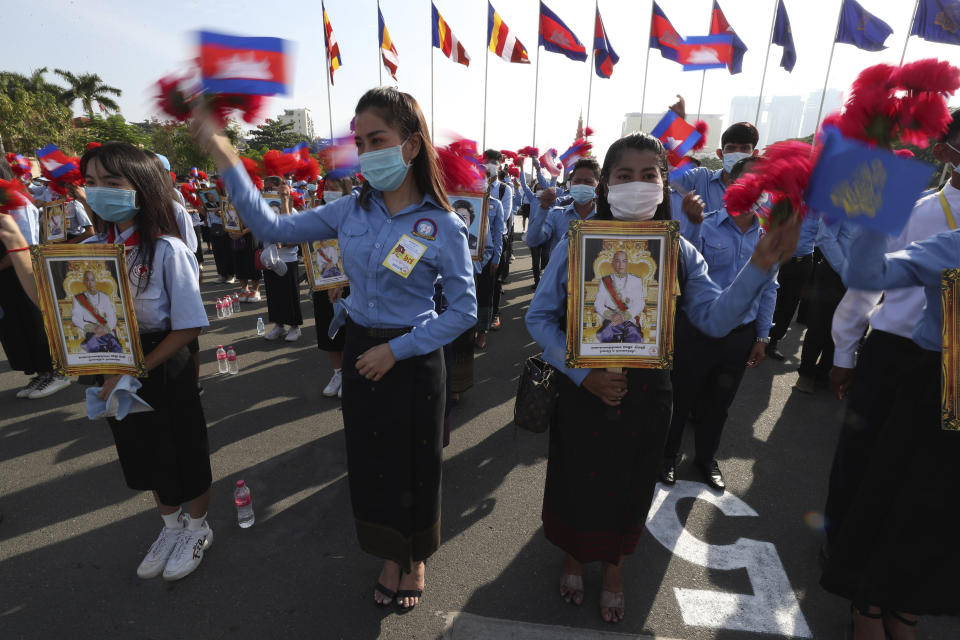 Cambodian students, holding the portrait of King Norodom Sihamoni, participate in the country's 67th Independence Day celebration, in Phnom Penh, Cambodia, Monday, Nov. 9, 2020. (AP Photo/Heng Sinith)