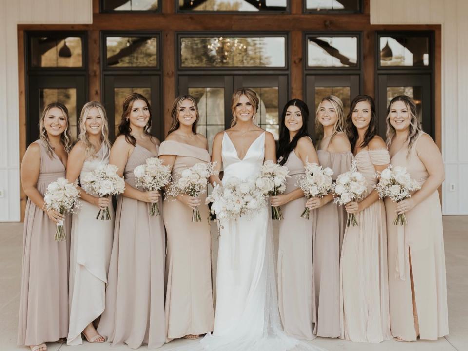A bride and her bridesmaids standing in front of her wedding venue.