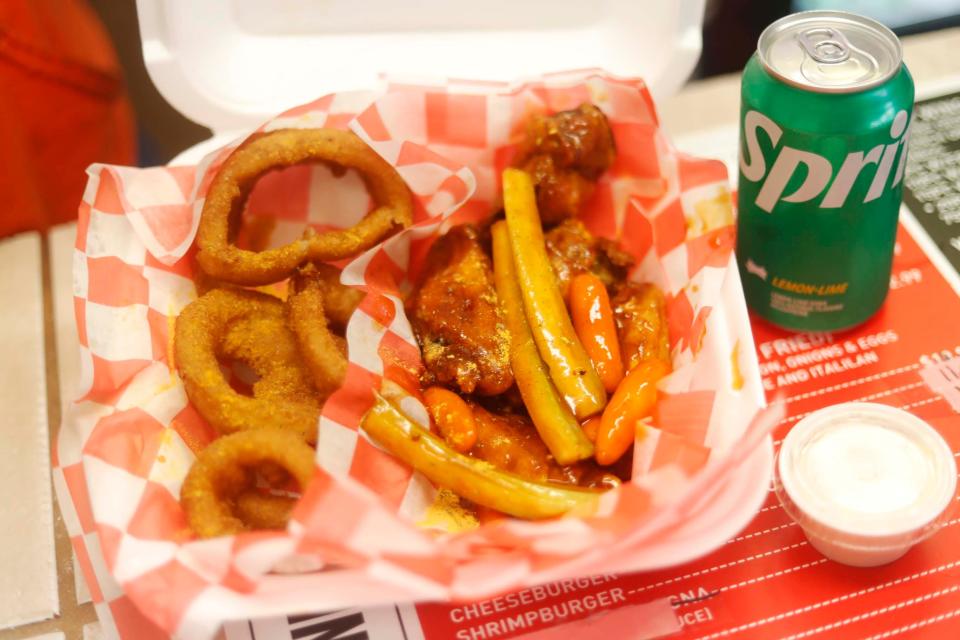 Riko and Tiffany Wiley own Riko’s Kickin’ Chicken in Memphis. Pictured are spicy honey garlic party wings and fried onion rings.