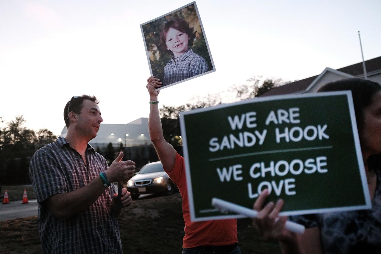 Mark Barden holds up a picture of his son Daniel who was killed in the Sandy Hook massacre during a vigil on October 4, 2017 in Newtown, Connecticut.