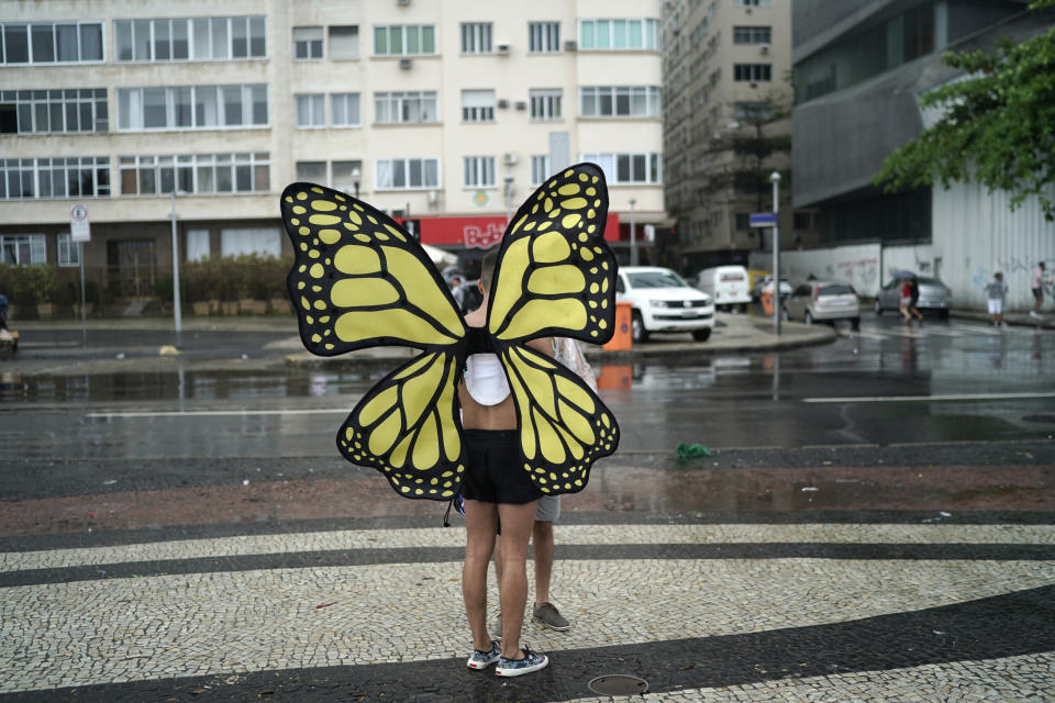 A person wearing butterfly wings stands on the sidelines of the annual gay pride parade along Copacabana beach in Rio de Janeiro, Brazil, Sunday, Sept. 22, 2019. (AP Photo/Leo Correa)