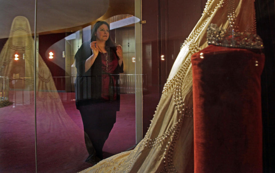 Soprano Angela Meade presses against a class display to view the 1921 Elvira costume from the first performance of Giuseppi Verdi's opera "Ernani," on Wednesday, Feb. 15, 2012 at the Lincoln Center in New York. Meade will reach an international audience in a single performance as she plays the lead female role, Elvira, in the Metropolitan Opera's high-definition global broadcast performance of "Ernani" on Saturday, Feb. 25. (AP Photo/Bebeto Matthews)