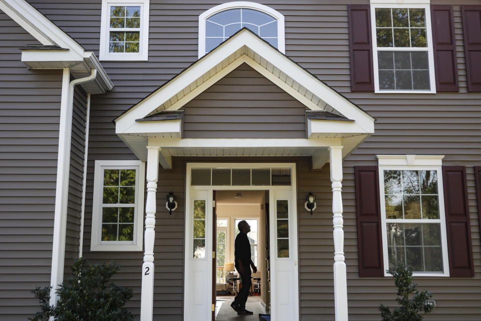 A homeowner tours his new home. The average rate on long-term mortgages increased this week to 6.81%.