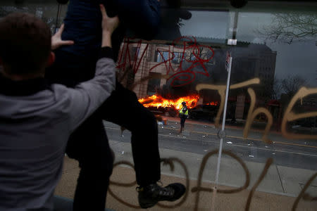 Activists leave the site of a limousine which was set ablaze during a protest against U.S. President Donald Trump on the sidelines of the inauguration in Washington, D.C., U.S., on January 20, 2017. REUTERS/Adrees Latif