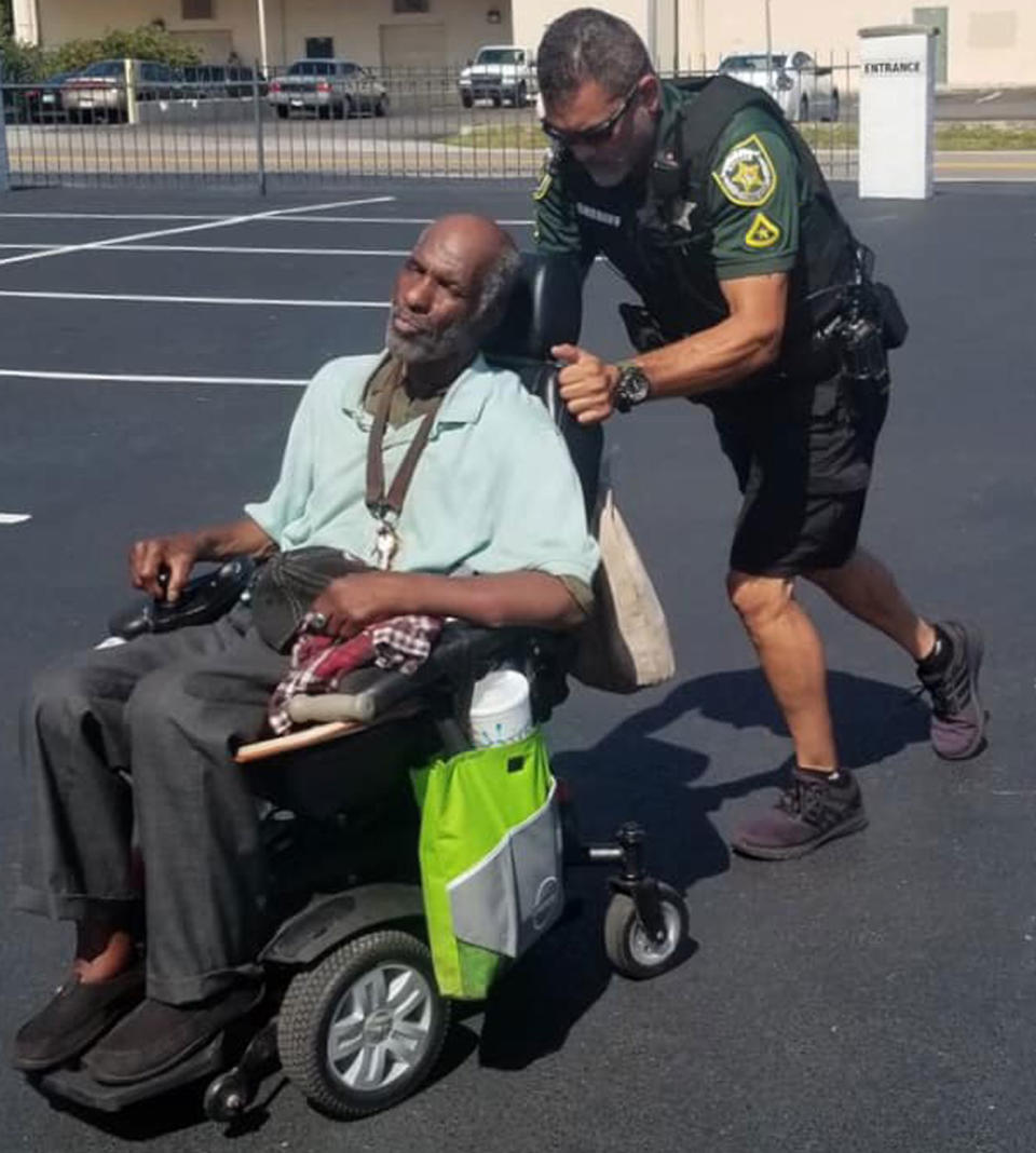 Deputy Danny Garciapagan seen pushing a man in a broken down electric wheelchair. The deputy pushed the chair with the man in it uphill and into a church for shelter as it was 32C outside.