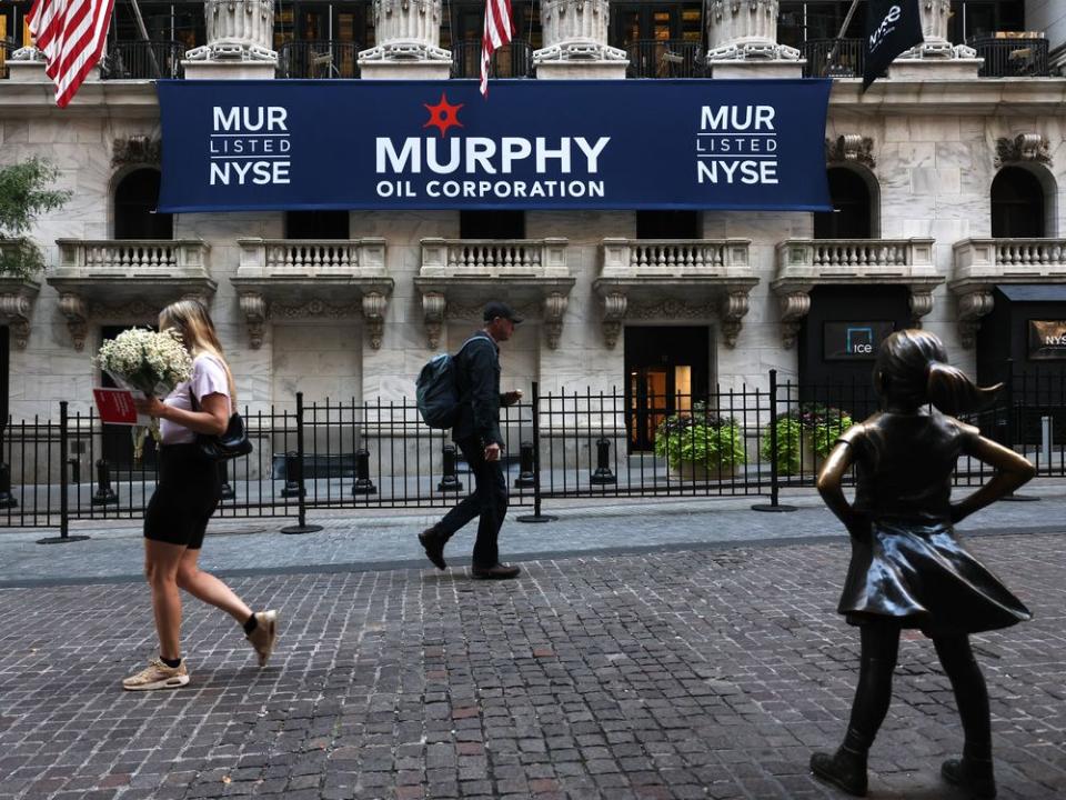  People walk past the New York Stock Exchange.