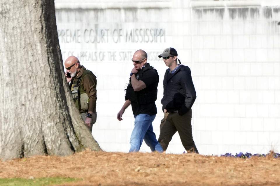 Lawmen patrol the grounds of the Mississippi State Capitol in Jackson, Miss., Thursday, Jan. 4, 2024, as they deal with a second consecutive day of bomb threats to the state house and to the Carroll Gartin Justice Building, which houses the state supreme and appellate courts. (AP Photo/Rogelio V. Solis)