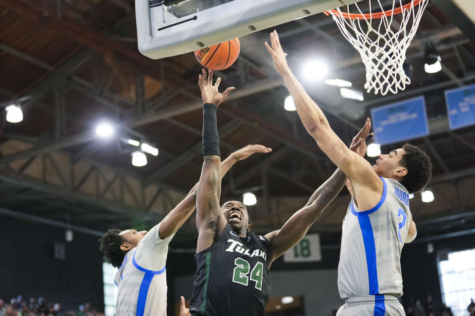 Tulane forward Kevin Cross (24) goes to the basket between Memphis forward Nick Jourdain (2) and forward Nae'Qwan Tomlin during the first half of an NCAA college basketball game in New Orleans, Sunday, Jan. 21, 2024. (AP Photo/Gerald Herbert)