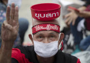 Pro-democracy supporter raises a three-finger salute, a symbol of resistance, with words on his head reading "Dissolution of Parliament" during a protest outside parliament in Bangkok, Thailand, Thursday, Sept. 24, 2020. Lawmakers in Thailand are expected to vote Thursday on six proposed amendments to the constitution, as protesters supporting pro-democratic charter reforms gathered outside the parliament building. (AP Photo/Sakchai Lalit)