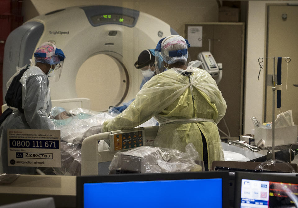 Medical workers prepare a COVID positive patient for a CT Scan at a clinic in Johannesburg Sunday, Dec. 27, 2020. South Africa's COVID-19 spike has taken the country to more than 1 million confirmed cases with hospitals reaching capacity and no sign of the new surge reaching a peak. (AP Photo/Shiraaz Mohamed.