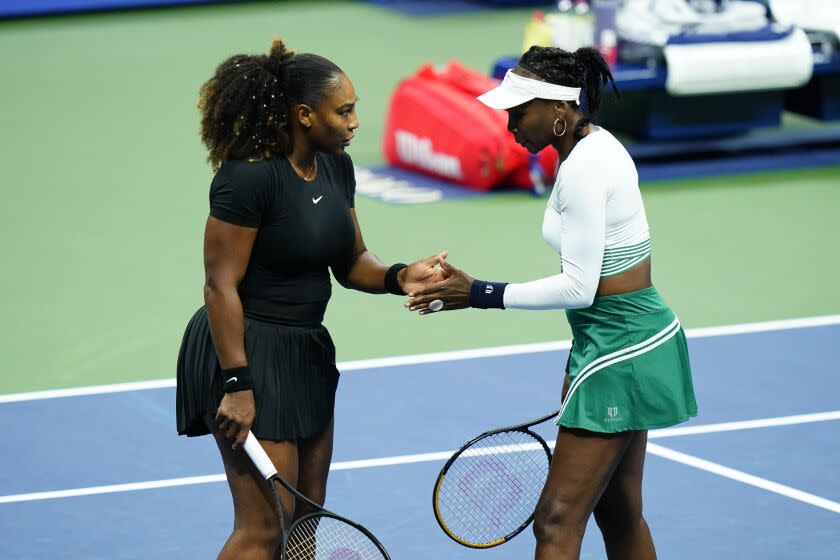 Serena Williams, left, and Venus Williams, of the United States, celebrate during their first-round doubles match.