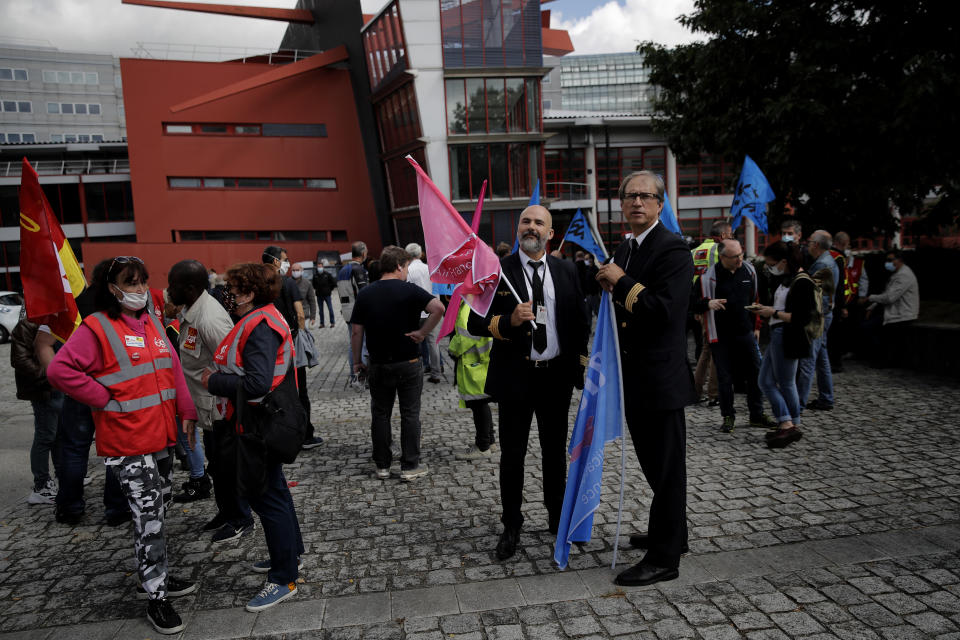 Air France workers gather during a protest in front of the company headquarters in Tremblay-en-France, outside Paris Friday, July 3, 2020. Air France is meeting with personnel representatives Friday to discuss thousands of job cuts after the virus pandemic grounded most flights and darkened prospects for future air travel. (AP Photo/Christophe Ena)