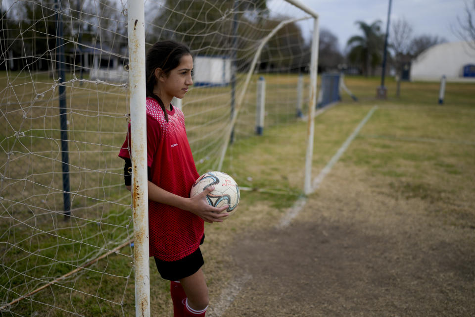 Candelaria Cabrera, a 12-year-old player with the Huracán de Chabas female team, poses for a portrait prior to a game with Alumni in Arequito, Argentina, Monday, June 19, 2023. In 2018 when she was seven, Candelaria was the only girl playing in a boys league. After a regional sports regulation forbid mixed teams in youth divisions, she and her family had to fight for her right to keep playing. (AP Photo/Natacha Pisarenko)