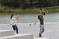 A family wearing face masks to help protect against the spread of the coronavirus enjoy themselves at a park in Seoul, South Korea, Wednesday, Sept. 23, 2020. (AP Photo/Ahn Young-joon)