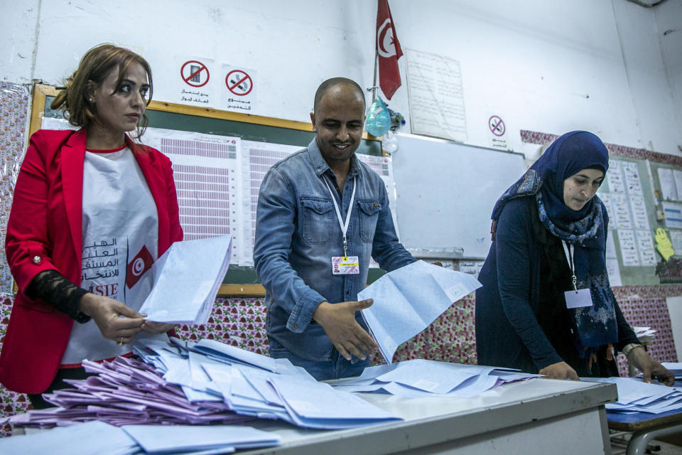 Election officials start counting marked ballots after polling stations closed during a parliamentary election in Tunis, Tunisia, Sunday, Oct. 6, 2019. Tunisians were electing a new parliament Sunday amid a tumultuous political season, with a moderate Islamist party and a jailed tycoon's populist movement vying to come out on top of a crowded field. (AP Photo/Riadh Dridi)