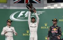 Formula One F1 - U.S. Grand Prix - Circuit of the Americas, Austin, Texas, U.S., 23/10/16. Mercedes' Lewis Hamilton of Britain raises his victory trophy as second placed finisher and teammate Nico Rosberg of Germany (L) and third placed Red Bull's Daniel Ricciardo of Australia (R) look on during the victory ceremony. REUTERS/Adrees Latif