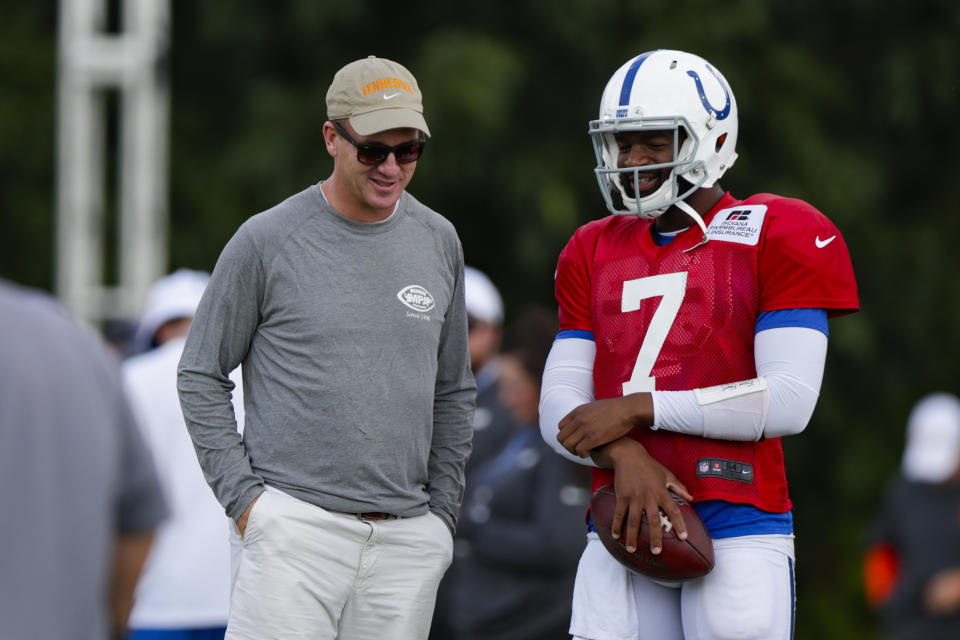 Indianapolis Colts quarterback Jacoby Brissett (7) talks with former Colts quarterback Peyton Manning during practice at the NFL team's football training camp in Westfield, Ind., Thursday, Aug. 15, 2019. The Colts held a joint practice with the Cleveland Browns. (AP Photo/Michael Conroy)