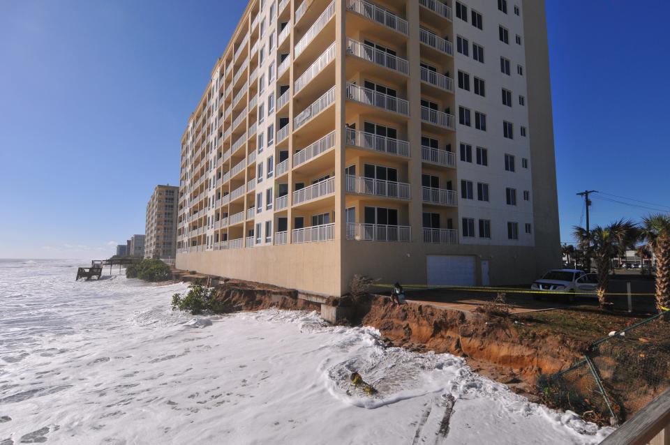 Waves lap up to the exposed base of the Oceana Oceanfront Condominium north tower on Friday.