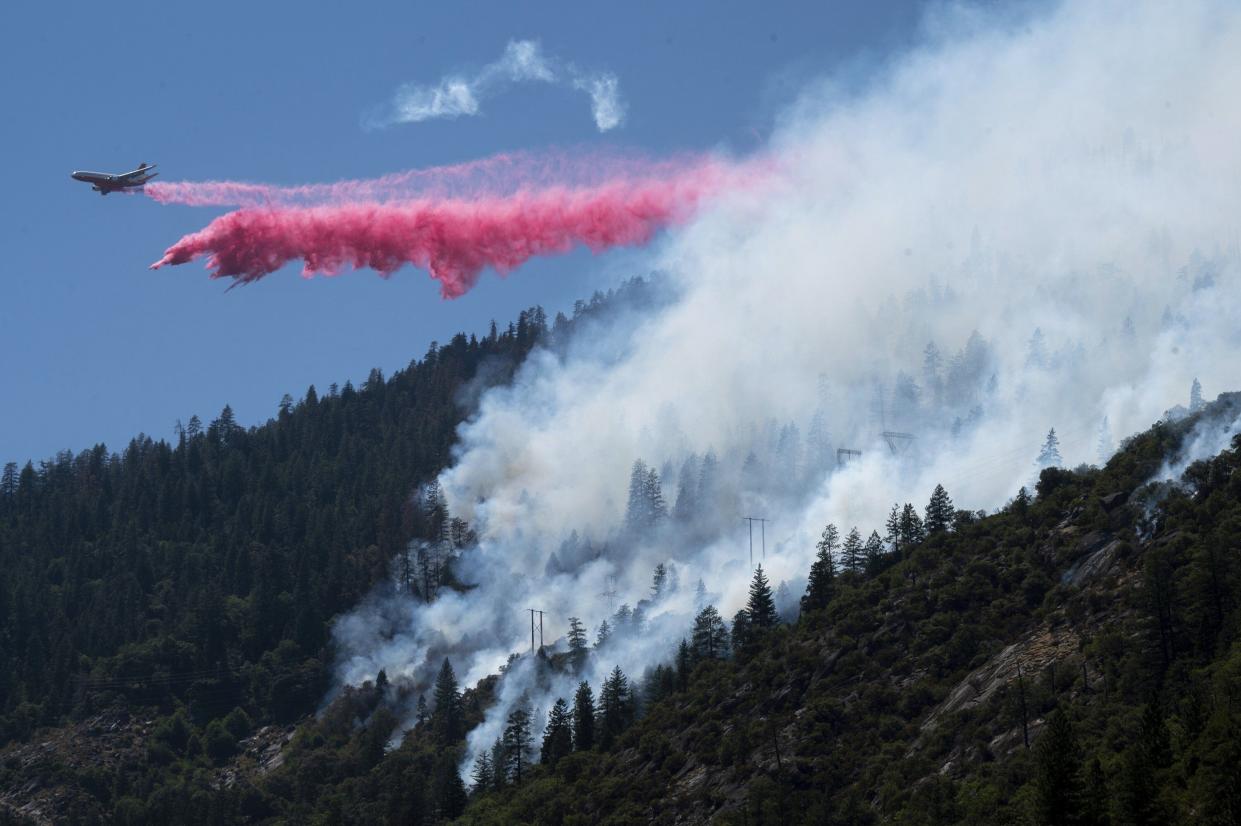 An air tanker drops fire retardant to battle the Dixie Fire in the Feather River Canyon in Plumas County, Calif. on  Wednesday, July 14, 2021. Residents were warned to be ready to evacuate as a growing wildfire bears down on two remote Northern California communities near a town largely destroyed by a deadly blaze three years ago. The fire that broke out Tuesday afternoon has chewed through more than 1.8 square miles of brush and timber near the Feather River Canyon area of Butte County.