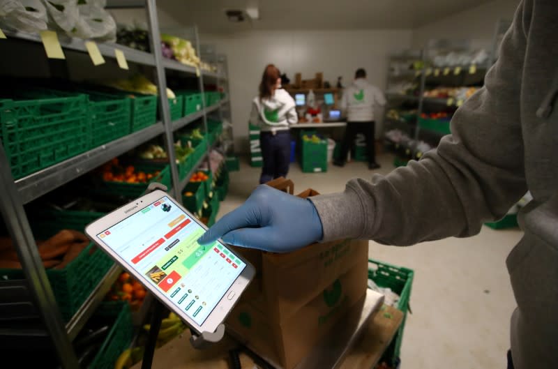 A member of staff of Farmy.ch, an online shop for home delivery of regional and organic products, wear gloves and prepares customers orders during the coronavirus