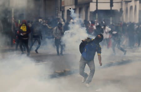 A demonstrator throws a stone during protests after Ecuador's President Lenin Moreno's government ended four-decade-old fuel subsidies in Quito