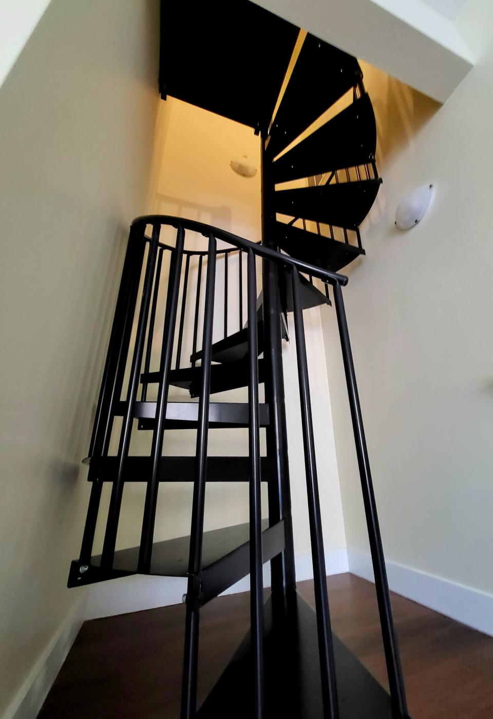 A spiral staircase, shown on Monday, Nov. 20, 2023, leads up from a side room to the rest of one available Marine City Manor condominium.