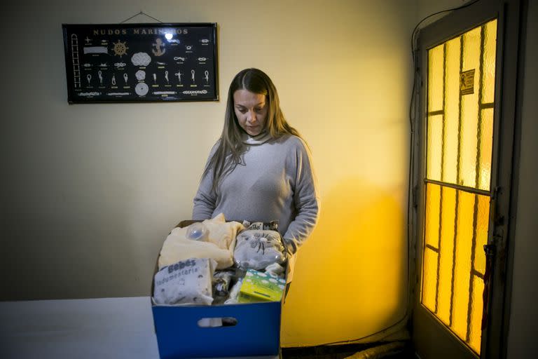 Vanesa, madre de Fran, bebé muerto en el Hospital Neonatal de Córdoba, acomoda la ropa que tiene como recuerdo, guardada en una caja