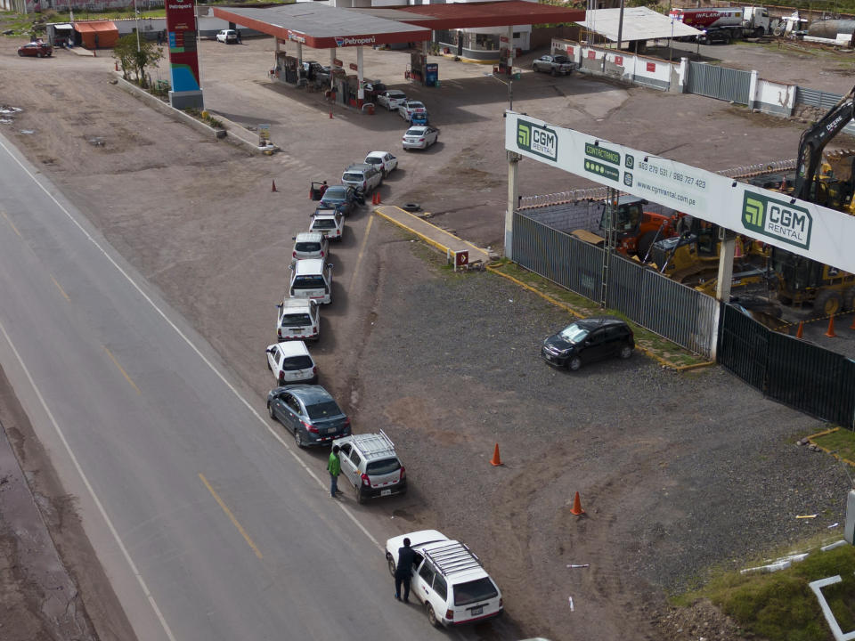 Drivers line up for fuel at a gasoline station in Cusco, Peru, Saturday, Jan. 28, 2023. Government officials said Thursday that police and the military will lift blockades set up across Peru by demonstrators asking for the resignation of President Dina Boluarte that the government says are causing shortages and price increases. (AP Photo/Rodrigo Abd)