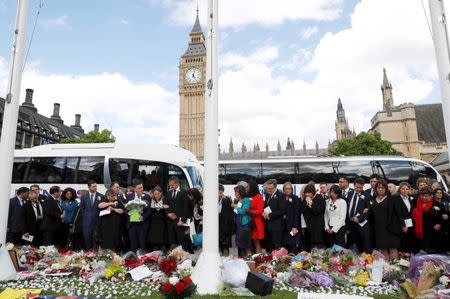 Members of Parliament view tributes to Labour MP Jo Cox who was killed outside her constituency surgery last week, on Parliament Square, London, Britain, June 20, 2016. REUTERS/Stefan Wermuth