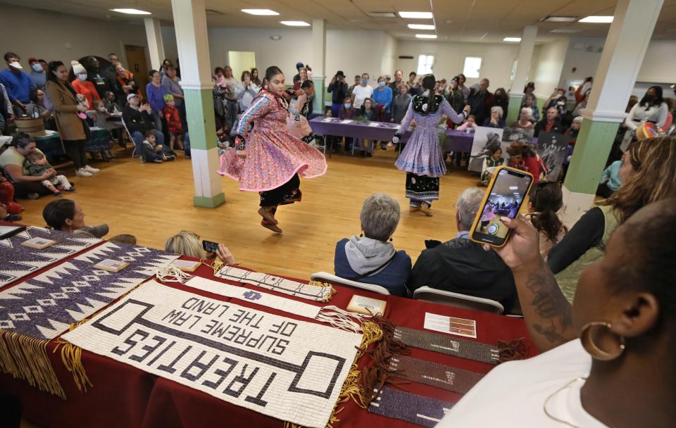 Members of the Allegany Seneca River Dancers perform a Smoke Dance for a packed house inside Lake Riley Lodge in Cobbs Hill Park, part of Rochester's First Annual Indigenous Peoples Day events Monday, Oct. 10, 2022.  On display on the tables are various Wampum belts. 