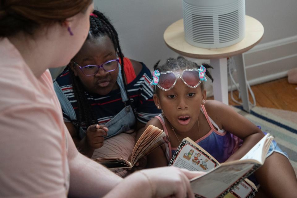 Tutor Erin Letourneau, left, reads to Wynter Whitfield, 8, and Caitlyn Heard, 8, at Brilliant Detroit in Detroit on Thursday, August 10, 2023.