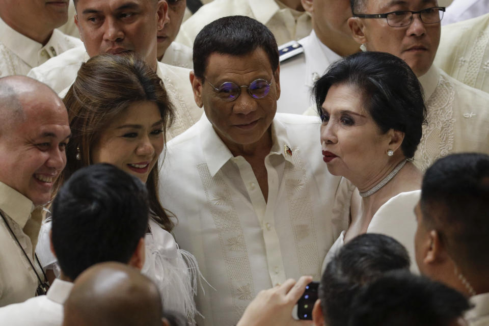 Philippine President Rodrigo Duterte, center, poses with other representatives after his 4th State of the Nation Address at the House of Representatives in Quezon city, metropolitan Manila, Philippines Monday July 22, 2019. (AP Photo/Aaron Favila)