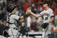 Arizona Diamondbacks' Daulton Varsho (12) and Tyler Clippard (36) celebrate after a baseball game against the Houston Astros Saturday, Sept. 18, 2021, in Houston. The Diamondbacks won 6-4 in 10 innings. (AP Photo/David J. Phillip)