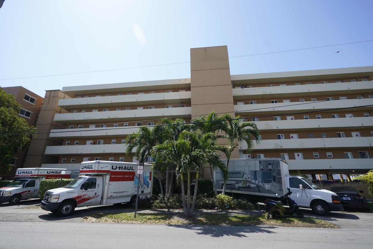 Moving vans and trucks are shown parked outside the Bayview 60 Homes apartment building, Tuesday, April 5, 2022, in North Miami Beach, Fla. 