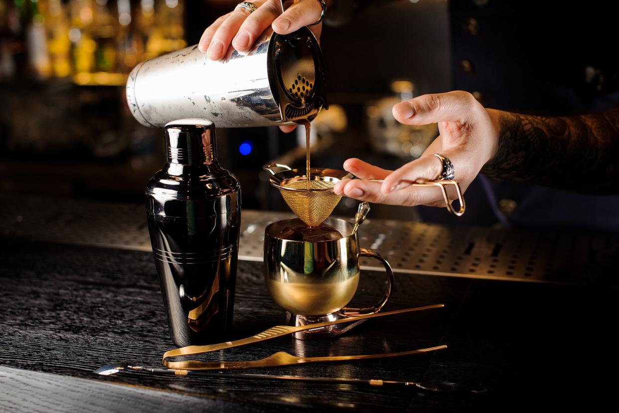 bartender pouring fresh and tasty summer drink into the copper mug