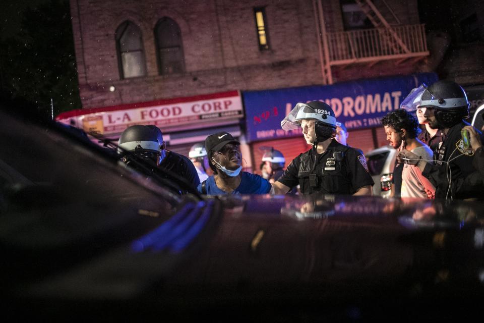 Courtney Taylor Mesidor talks to fellow protesters after being arrested for breaking a curfew during a solidarity rally calling for justice over the death of George Floyd, Friday, June 5, 2020, in the Brooklyn borough of New York. Floyd, an African American man, died on May 25 after a white Minneapolis police officer pressed a knee into his neck for several minutes even after he stopped moving and pleading for air. (AP Photo/Wong Maye-E)