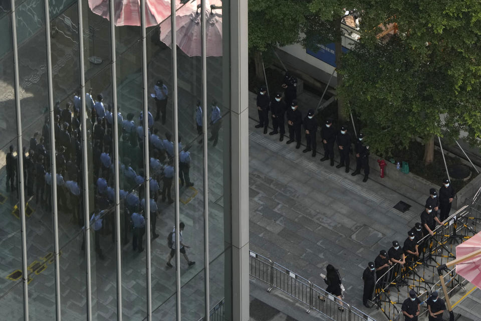 Chinese police and security personnel prepare for duty outside the Evergrande headquarters in Shenzhen, China, Friday, Sept. 24, 2021. Things appeared quiet at the headquarters of the heavily indebted Chinese real estate developer Evergrande, one day after the day it had promised to pay interest due to bondholders in China. (AP Photo/Ng Han Guan)