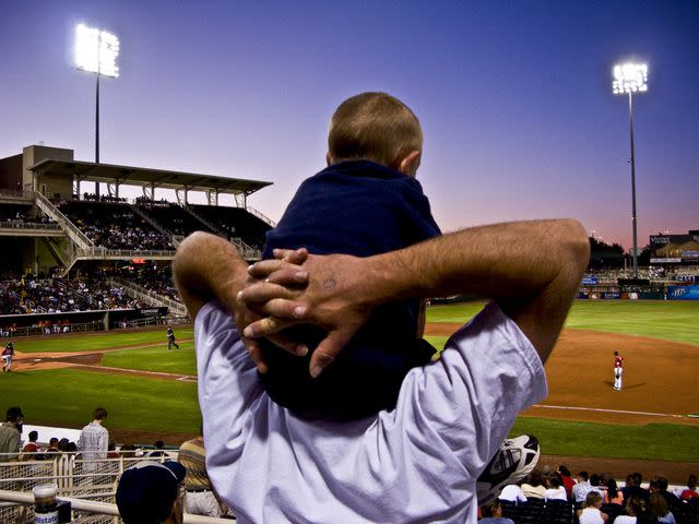 Getty Images/Ray Laskowitz Father with son on shoulders at an Isotopes baseball game