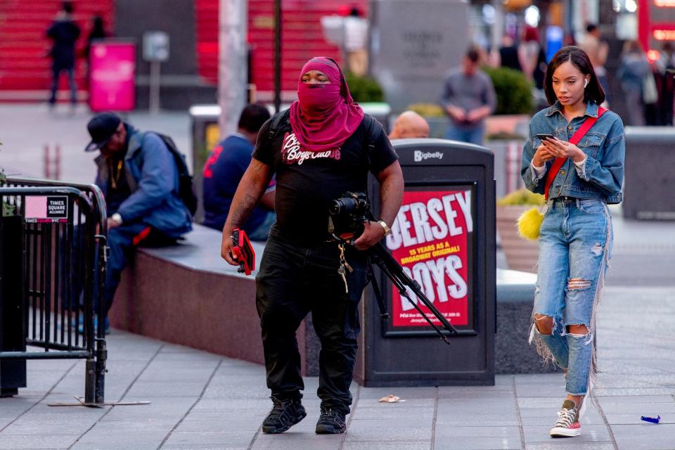 UNITED STATES: A photographer covers his face in New York City's Times Square during the COVID-19 pandemic.