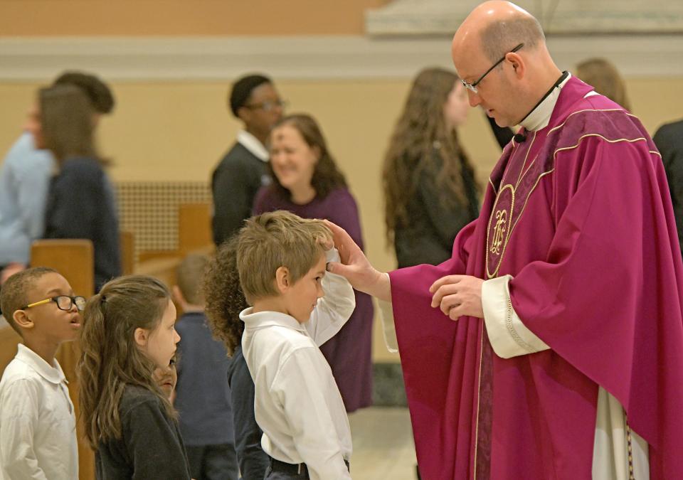 The Rev.  John Miller anoints students with ashes Wednesday at St. Peter's Catholic Church in Mansfield. Ash Wednesday marks the beginning of Lent, a 40-day season of prayer, fasting, and almsgiving leading up to Easter.