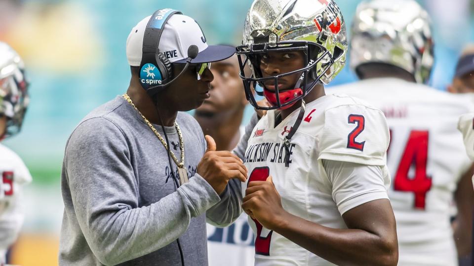 deion sanders talking to his quarterback son shedeur sanders during a football game