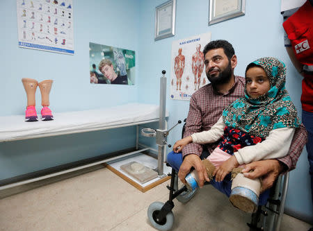 Maya Meri, 8, waits with her father Muhammed Ali Meri at a prosthetic center in Istanbul, Turkey, July 5, 2018. Picture taken July 5, 2018. REUTERS/Osman Orsal