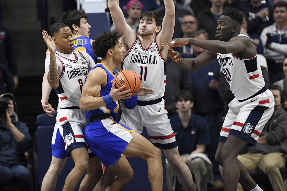 Xavier's Colby Jones is guarded by UConn's Jordan Hawkins, left, Alex Karaban, center, and Adama Sanogo, right, in the first half of an NCAA college basketball game, Wednesday, Jan. 25, 2023, in Storrs, Conn. (AP Photo/Jessica Hill)