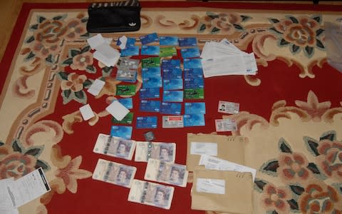 Credit and debit cards that were created in victim's names - Credit: West Midlands Police/PA