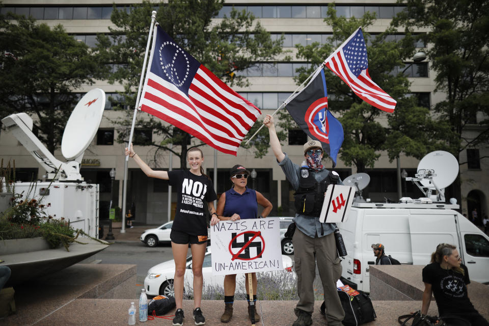 <p>Counter-protesters hold signs and flags ahead of the Unite the Right 2 rally in Washington, D.C., U.S., on Sunday, Aug. 12, 2018. The rally, being held in Lafayette Park near White House, marks the one-year anniversary of the Charlottesville, Virginia, rally where a car driven into a crowd of counter protesters killed 32-year-old Heather Heyer. (Photo: Aaron P. Bernstein/Bloomberg via Getty Images) </p>
