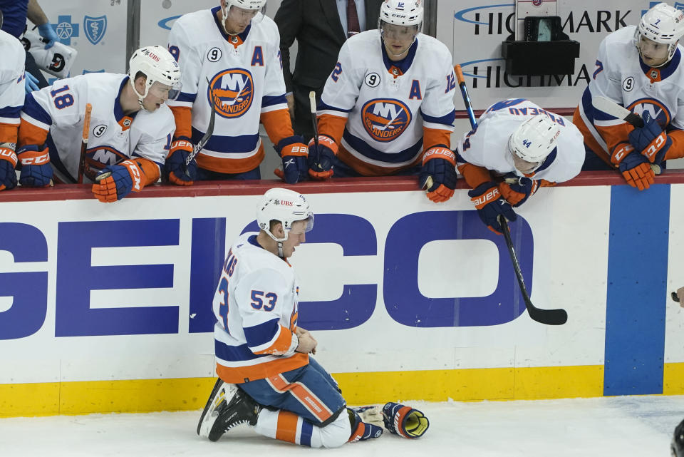 New York Islanders' Casey Cizikas (53) kneels on the ice in front of his bench after he was hit by a stick during the first period of an NHL hockey game against the Pittsburgh Penguins, Thursday, April 14, 2022, in Pittsburgh. Penguins' Mark Friedman was penalized 4 minutes for high-sticking on the play. (AP Photo/Keith Srakocic)