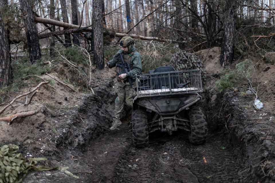 A Ukrainian soldier gets off a quad bike in a forest in the direction of Kreminna, in the Donetsk Oblast, on Feb. 15, 2024.